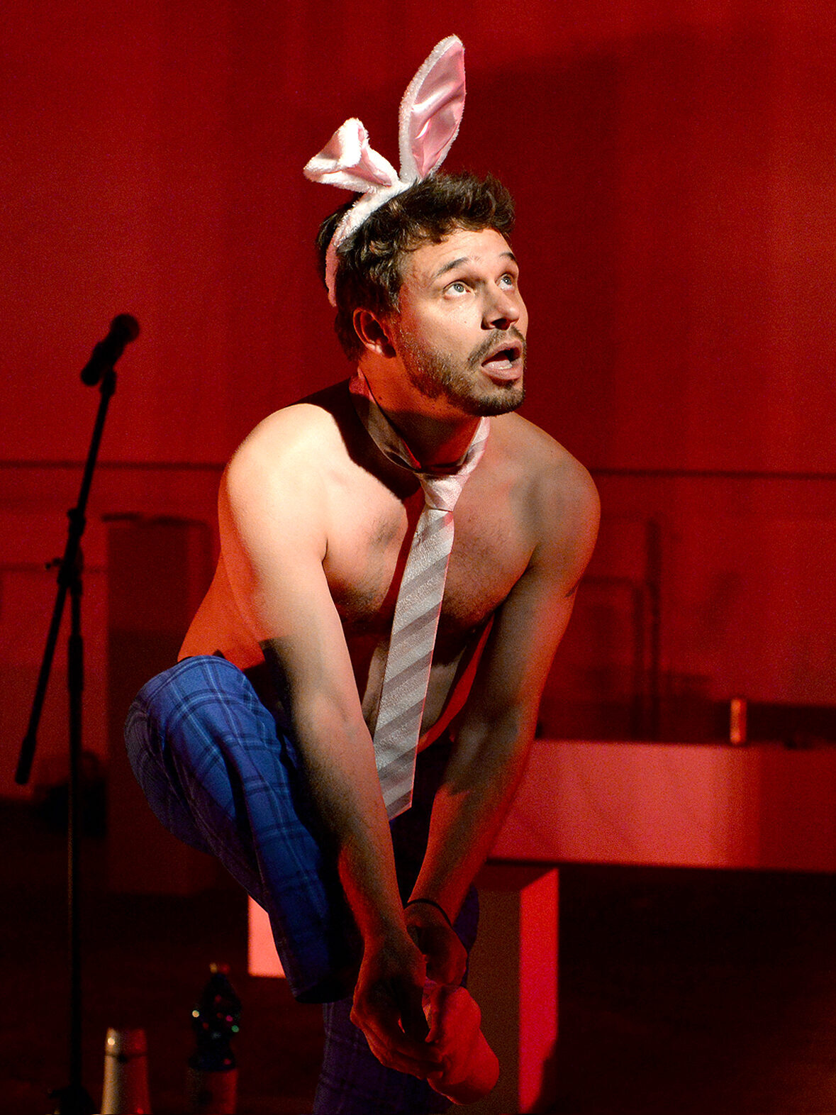 Jonas Baeck mit Hasenohren und Krawatte auf einer Theaterbühne