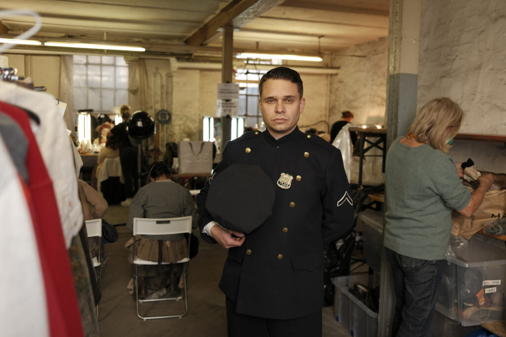 Jonas Baeck in einem Polizeikostüm an einem Filmset